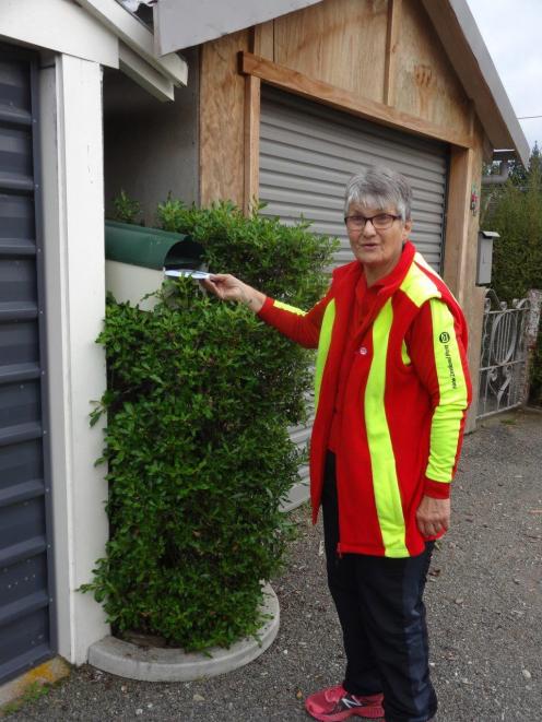 Joan Paul delivers a letter to a Palmerston letterbox on her last delivery day last Friday. Photo...