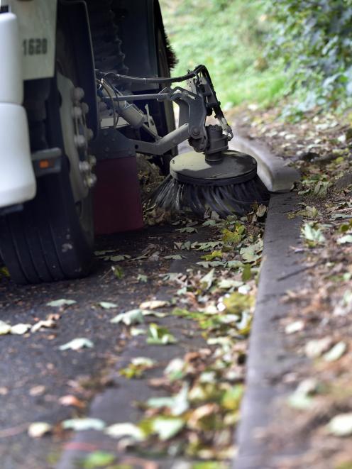 A Downer truck clears leaves from Neidpath Rd, Mornington, yesterday in preparation for heavy rain expected today. Photo by Peter McIntosh.