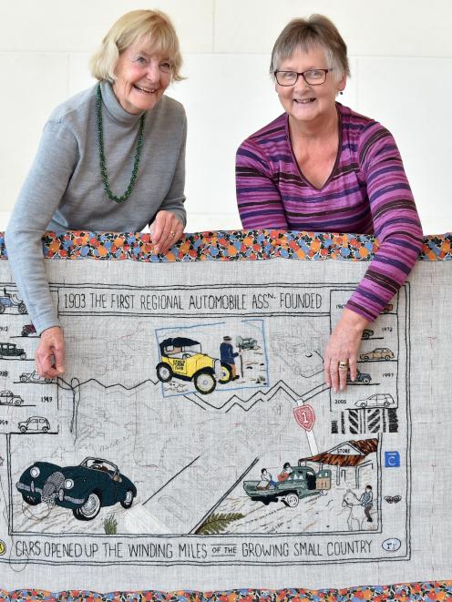 During a public stitching event at Toitu Otago Settlers Museum, Dunedin embroiderers Jeanette Trotman (left) and Judy Mason display a stitched panel devoted to the founding of New Zealand's first regional Automobile Association, in Otago. Photo: Peter McI