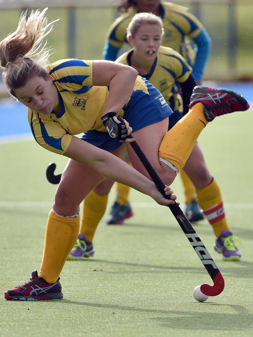 Greta Pearce, of Taieri Tigers, plays the ball watched by team-mate Emma Simcock-Smith during their team's Dunedin premier women's hockey match against Kings United at the McMillan Hockey Turf on Saturday. Taieri won 6-0. Photo: Peter McIntosh.