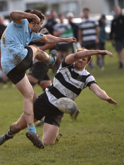 University's Tom Morrison kicks the ball into Southern's Ben Leggett during their Dunedin premier club rugby match at Bathgate Park on Saturday. Photo: Peter McIntosh