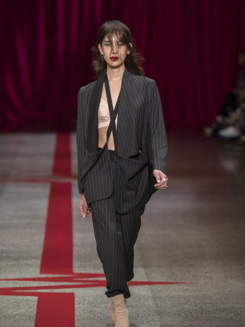 A model wears a Company of Strangers’ interpretation of the pinstripe suit during the label’s...