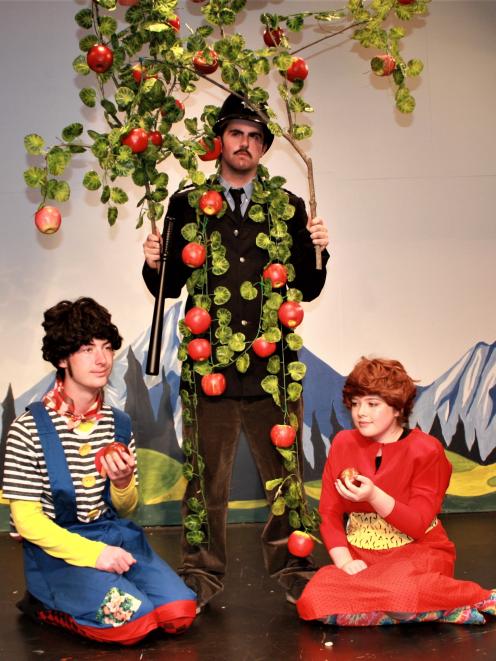 Badjelly the Witch characters Tim (Zac Henry, kneeling at left) and Rose (Tylah Harris) share the fruits offered by Nigel the apple tree (Rob Monzari) in a scene from Spike Milligan's delightfully bonkers comedy. Photo: Supplied
