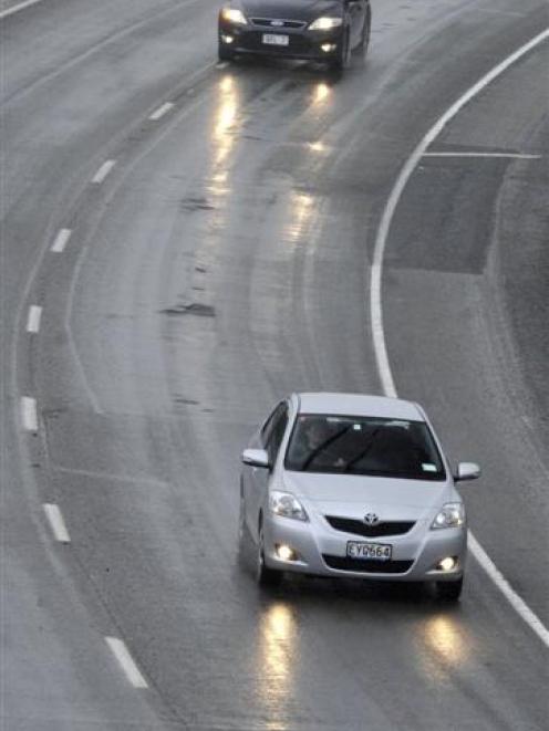 Motorists negotiate broken tarseal on the Southern Motorway, near Green Island. Photo by Matthew...