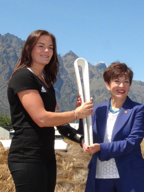 Para athlete Holly Robinson passes the Queen's Baton to Governor-General Dame Patsy Reddy at Queenstown Airport yesterday. Photo: Louise Scott