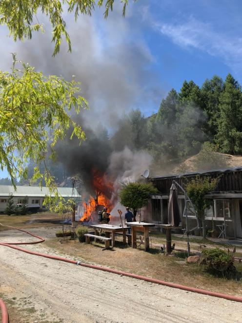 Firefighters work to contain a fire in Queenstown today. Photo: Jim Pollard