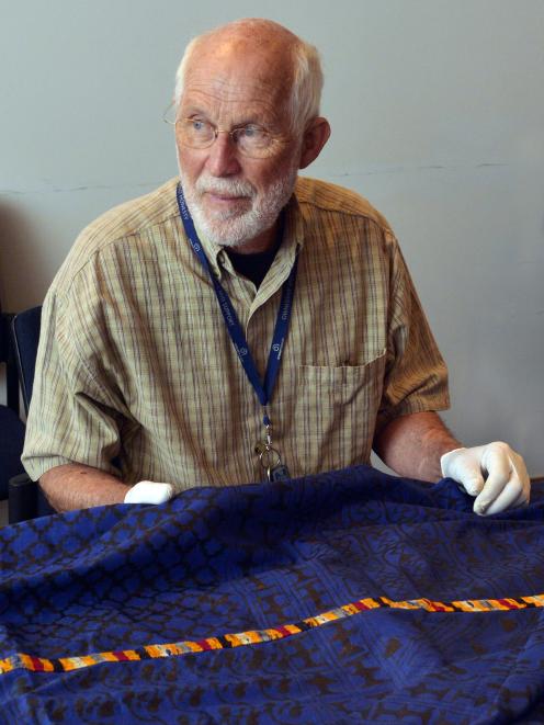 Otago Museum honorary curator, African material, Joel Vanderburg, examines a big adinkra cloth...