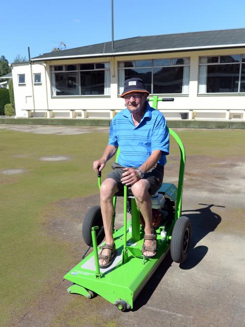North East Valley Bowling Club greenkeeper Neill Williams rolls the barren-looking playing surface at the club yesterday. Photo: Linda Robertson
