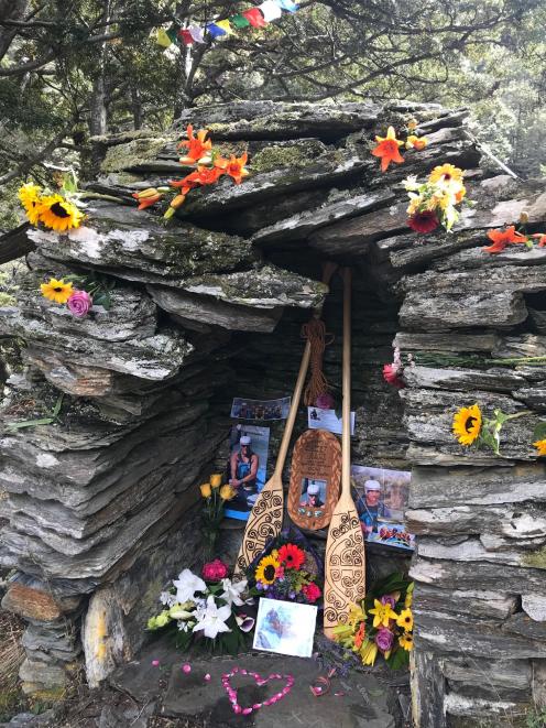 A carved plaque and paddles have been placed near the river.
