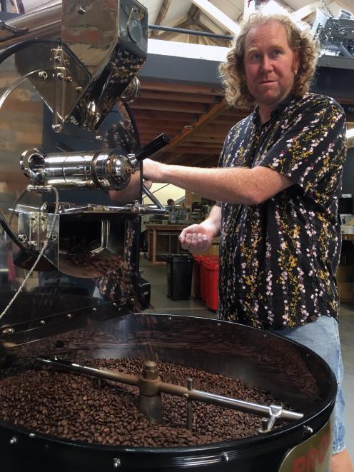 Grid Coffee Roasters co-owner Gavin Mockford finishes roasting some coffee beans at the business’...