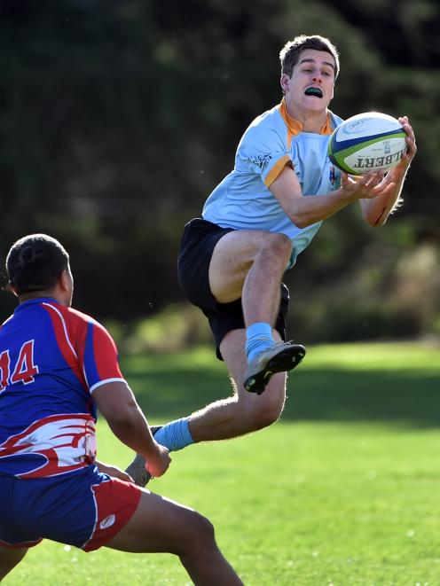 University winger Cam Gerlach catches the ball while Harbour winger Ngana Nicholas looks to...