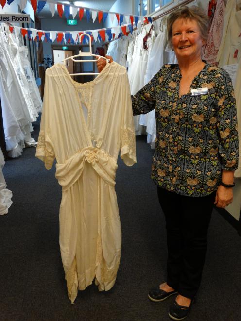 Iona Enliven Care Home activities co-ordinator Diane McCone with a wedding dress worn in 1920....