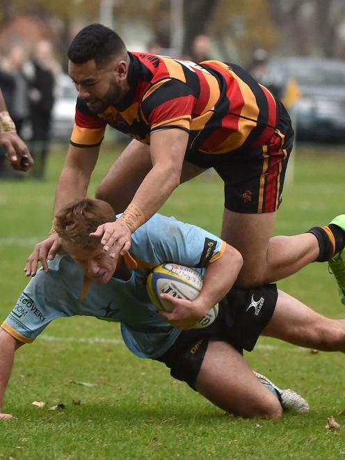 University loose forward Jack McHugh is tackled by Zingari-Richmond second five-eighth Keenan...