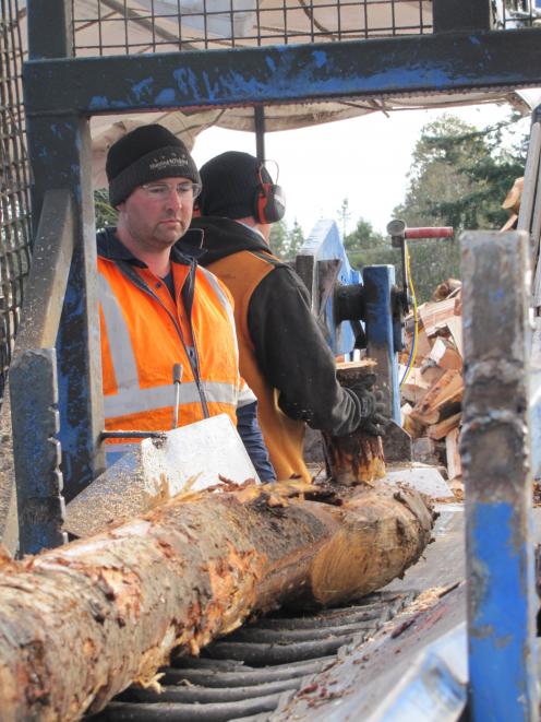 Ivan Murdoch and Alex Martin turning wet logs into wet firewood.