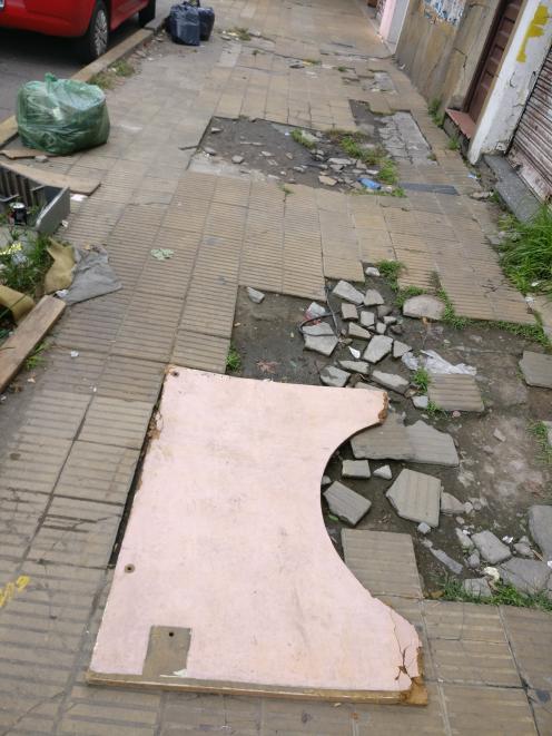 A broken footpath is typical of the standard of the streets of Buenos Aires. 