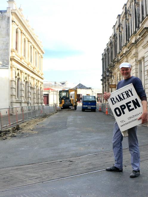 Harbour Street Bakery owner Ed Balsink carries a sign for the Tyne St entrance of Harbour St to...