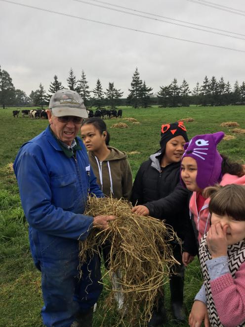 Brian O'Connell (left) gives pupils from the van Asch Education Centre in Christchurch the chance to smell some silage. Photo: New Zealand Young Farmers