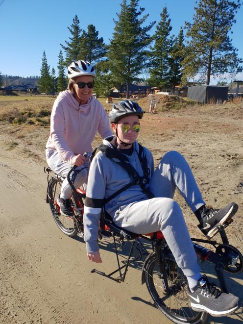 Pippa Wellstead (left) and her son Jack (19) try out the new tandem mountain bike, which will benefit people wanting to cycle the Otago Central Rail Trail, particularly those who cannot ride a bike independently due to a disability. Photo: Supplied