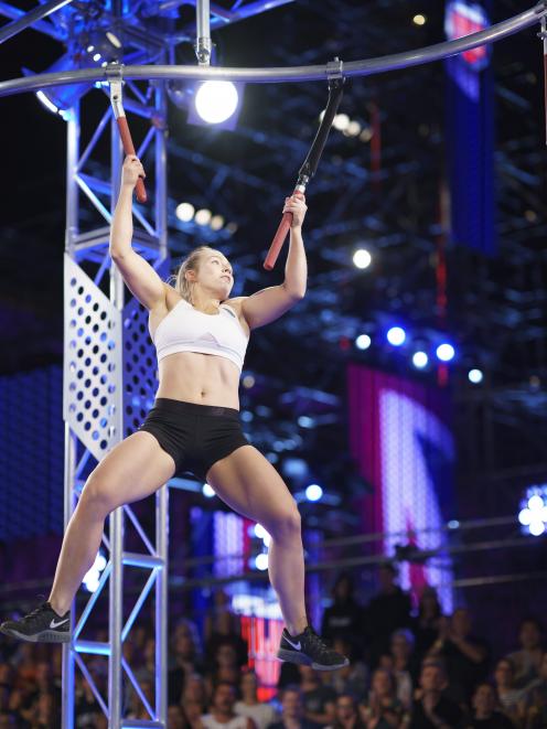 India Henry (22), formerly of Gore, holds on as she crosses through obstacles during season two of Ninja Warrior Australia. Photo: Supplied