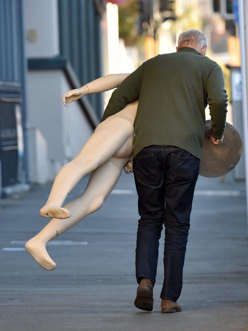 A man carries a mannequin up Stuart St during the Fortune Theatre clearance auction on Saturday. 