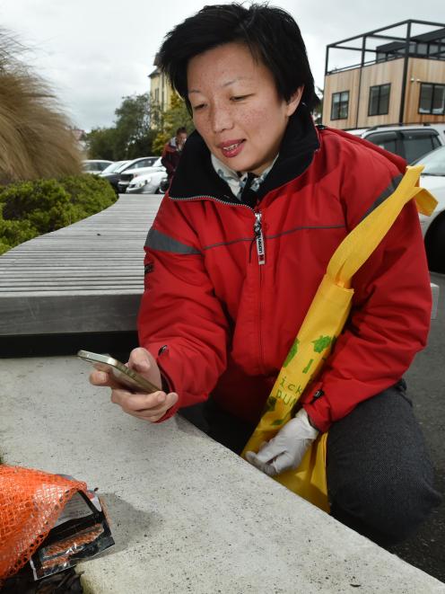 Siau-Jiun Lim photographs litter for her art project in Forth St on Monday afternoon. Photo: Gregor Richardson