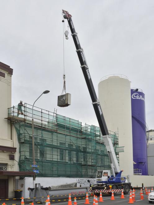A section of parapet is removed from the former Cadbury Dairy building to make way for the restoration of its heritage facade. Photo: Gerard O'Brien
