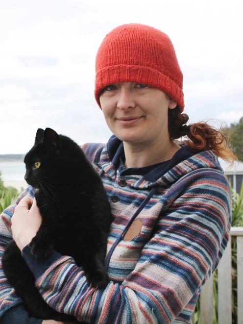 Cat-lover Nico Jarvis, of Omaui, cuddles up with her neighbour’s 8-year-old cat, Nhabuz Fishaw. Photo: Sharon Reece
