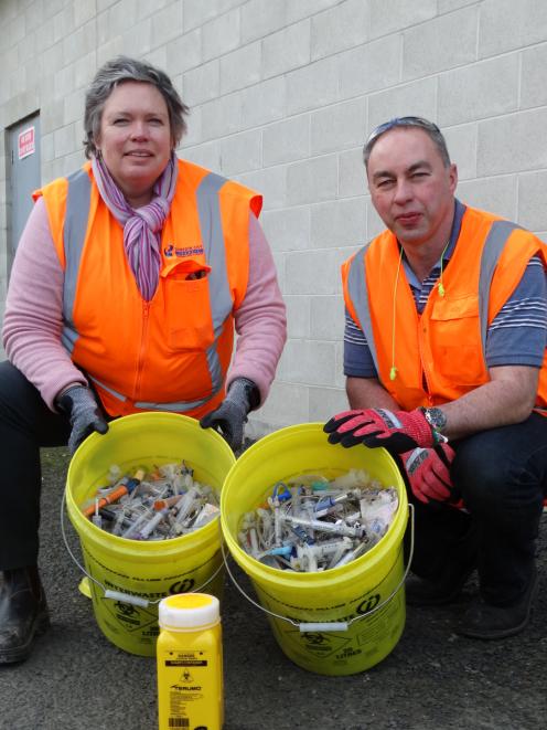 DCC waste and environ­mental solutions education and promotions officer Catherine Gledhill and recycling baling plant manager Jeff Gamble with a collection of syringes, needles and other dangerous objects found in recycling bins in the past year. Photo: B
