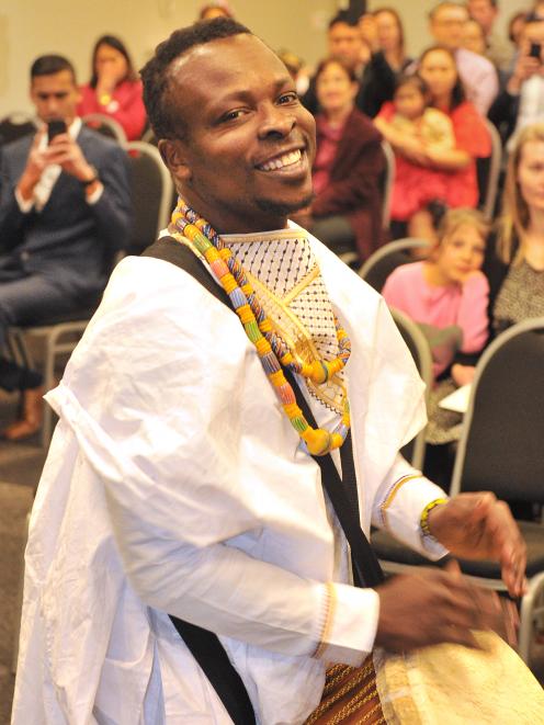 New citizen Robert Fugah, originally from Ghana, performs a traditional African drum song in front of the other new citizens at the end of a ceremony in the Glenroy Auditorium yesterday. Photo: Christine O'Connor