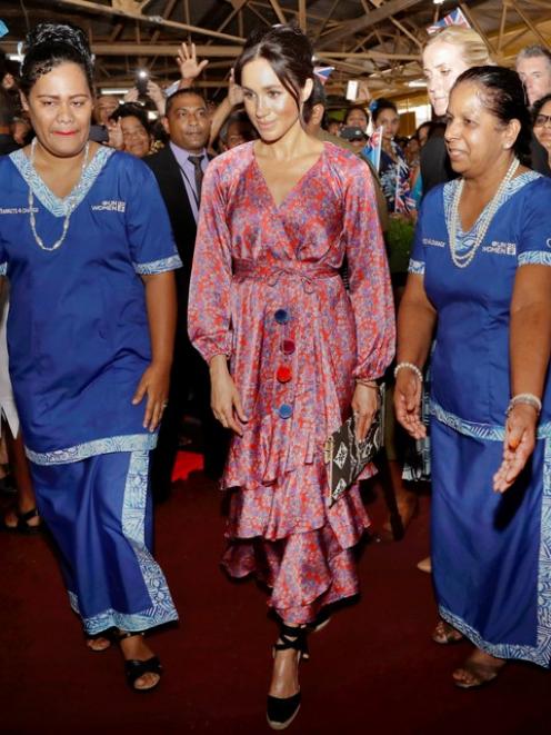 Meghan, Duchess of Sussex, walks with locals during a visit to a market in Suva, Fiji. Photo: Reuters