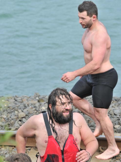 Dunedin personal trainer Alex Spenceley (right) walks along the Ravensbourne shore yesterday...