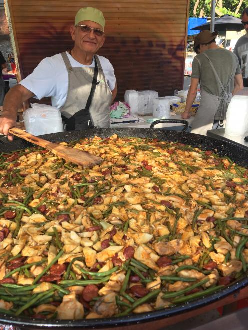 Lawrence Walker, of "Paella @ Sunset" serves up dinner at the Mindil Beach Sunset Markets, in...