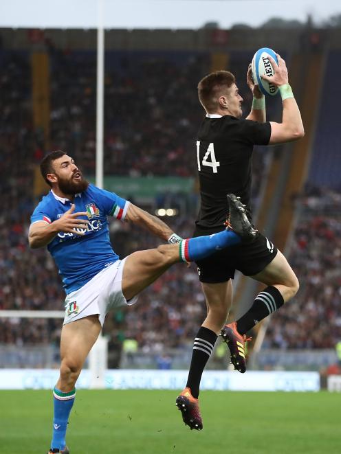 All Black wing Jordie Barrett collects the high ball ahead of Italy fullback Jayden Hayward to...