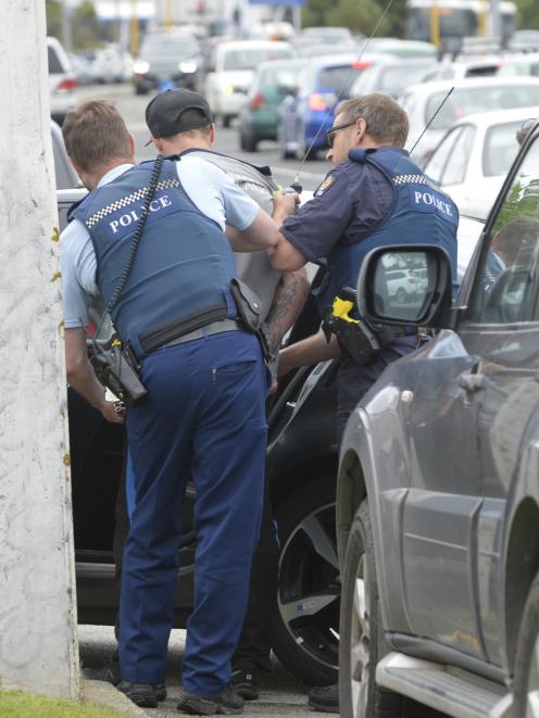 Officers arrest a man after he evaded police at a checkpoint in Dunedin this afternoon. Photo:...