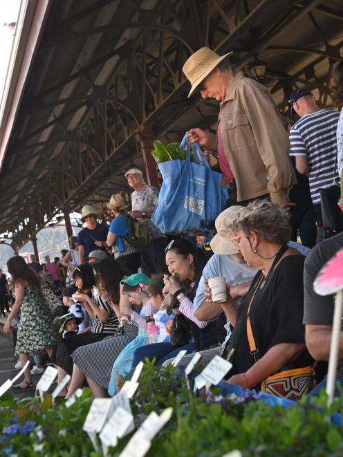 Shoppers seek shade under the platform canopy of the Dunedin Railway Station to enjoy food bought at the Otago Farmers Market on Saturday. Photo: Christine O'Connor