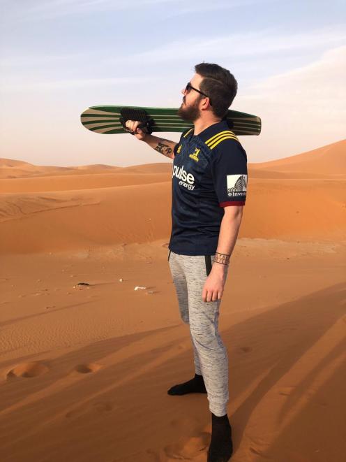 Billy Heron sports his Highlanders shirt while sandboarding. Photo: Matthew Wicks