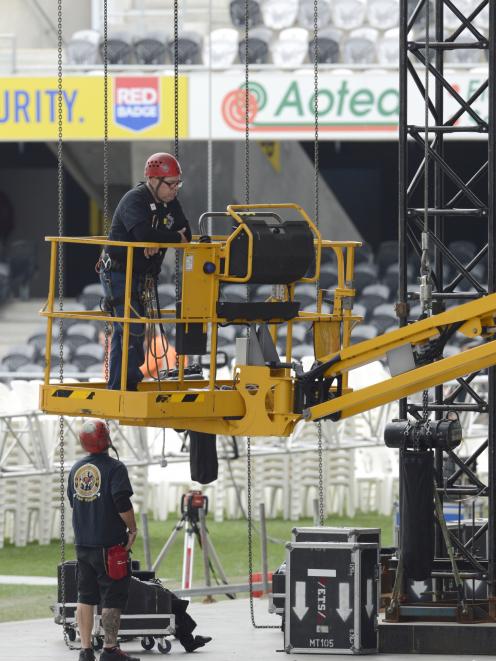 Contractors erect barriers between temporary seating.