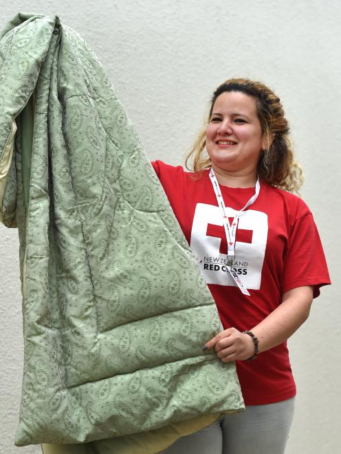 Red Cross volunteer Hadil Catherina prepares bedding for new arrivals. Photo: Peter McIntosh