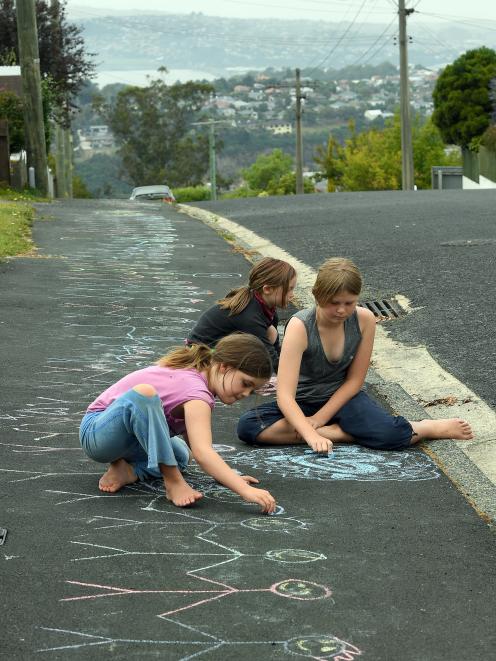 The Patterson sisters of Stratham St, in Brockville, (from left) Zoe (9), Erin (6) and Ada (11), have drawn a message to their neighbours whom they think were connected to the Christchurch tragedy. Stretching the well-walked route between houses of immigr