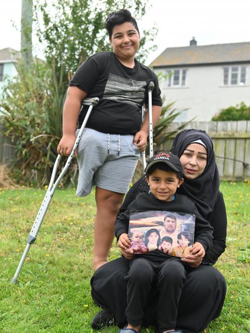 Pine Hill former refugees Nisrine (36), Kasem (14) and Mohammad (5) Zarzar in their garden after the Christchurch mosque attacks with a picture of dead relatives including children Lamar, Samei, Basal and father Mohammad. Photo: Christine O'Connor