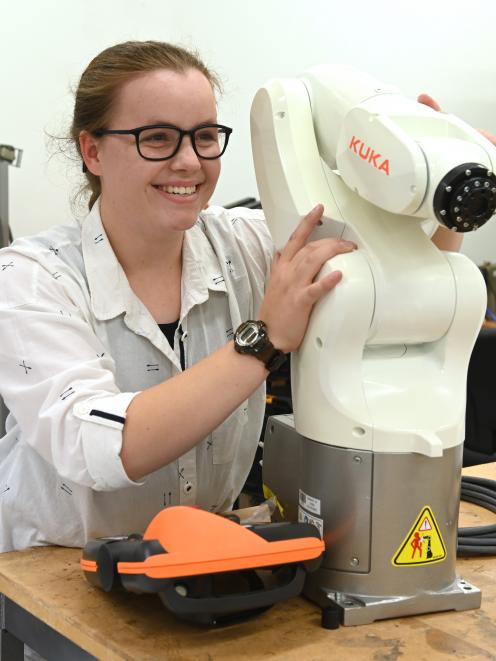 Aspiring electrical engineer Hanri de Bruin poses with an automated arm, similar to the one she...