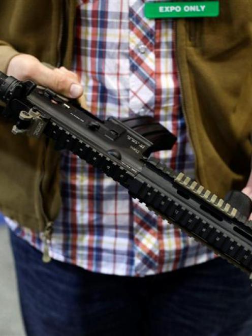 An attendee holds an assault style weapon at the 7th annual Border Security Expo in Phoenix,...