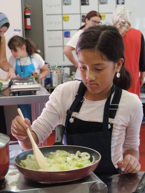 Erena Piho (9) stirs vegetables for the vegetable quiche.