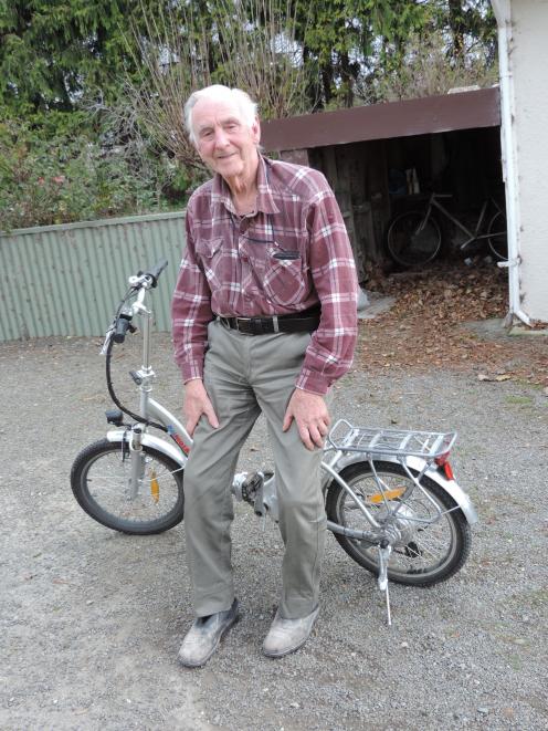 Jim Quested rides his e-bike to the hen houses. Photo: Sally Brooker