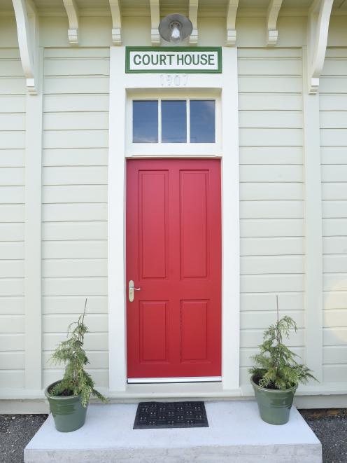 The original courthouse sign hangs above a rugby red front door. The 1907 building was originally...