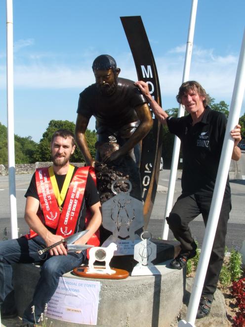 Allan Oldfield is pictured with his  world championship trophies next to a shearing statue in downtown Le Dorat, France, with his father and coach Phil Oldfield, who placed second in the 2017 world championships.Photo: Supplied