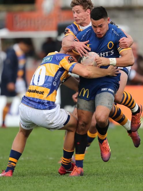 Otago midfield back Sio Tomkinson is tackled by Bay of Plenty first five-eighth Dan Hollinshead...