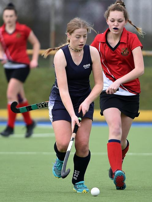 Otago Girls' High School hockey player Tessa Buschl (18), of Outram, dribbles a ball while being...