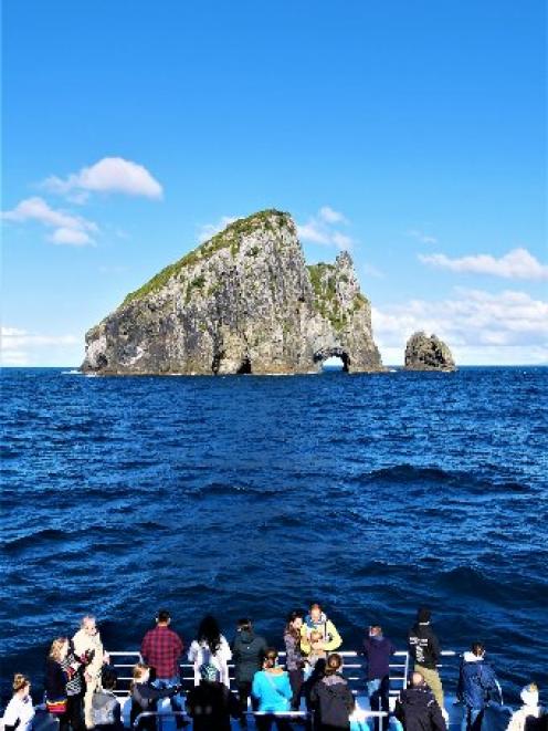 Hole in the Rock colossus, Motu­kokako Island, rises from the sea just off Cape Brett, Bay of...