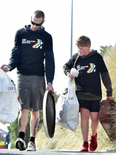 David Heads and son Aiden (11), of Dunedin, carry rubbish from the sand dunes at St Kilda during...